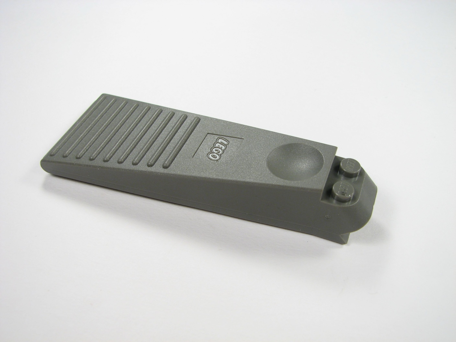 An older gray LEGO brick separator photographed on a white background